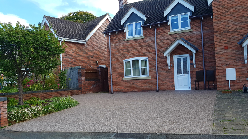 image of a house with a resin bound driveway, front garden and a tree
